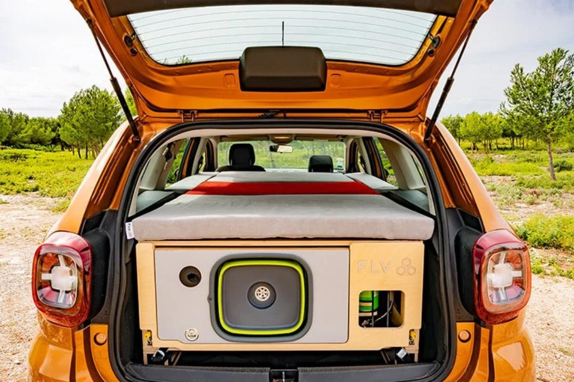 Dacia Duster naranja maletero abierto con molduras de madera y colchón