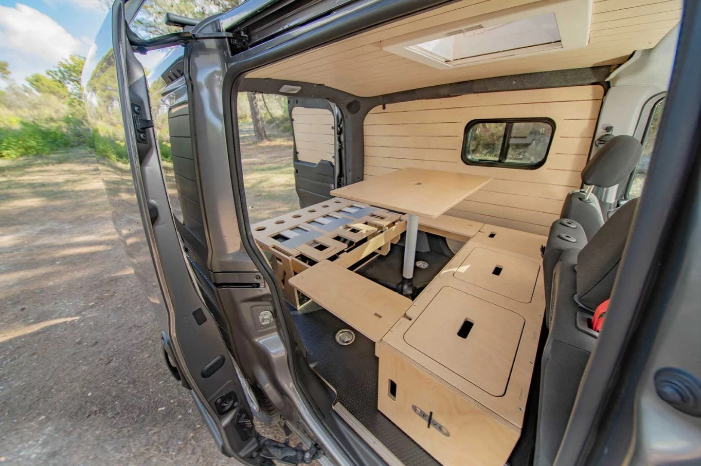 interior de una furgoneta con disposición de cama y mesa