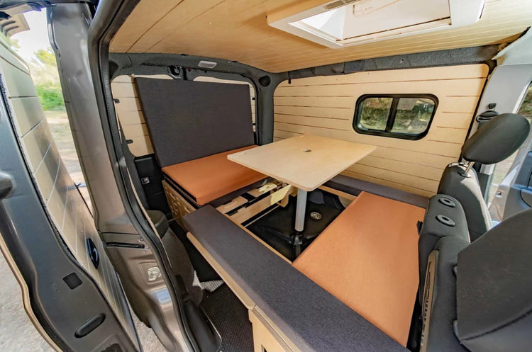 interior de una furgoneta con accesorios de madera, una mesa y una caja