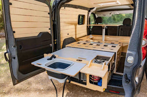 interior de un vehículo con accesorios de madera y zona de cocina