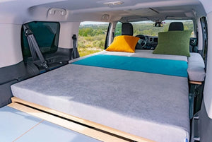 colchón gris y azul en un van con puertas abiertas