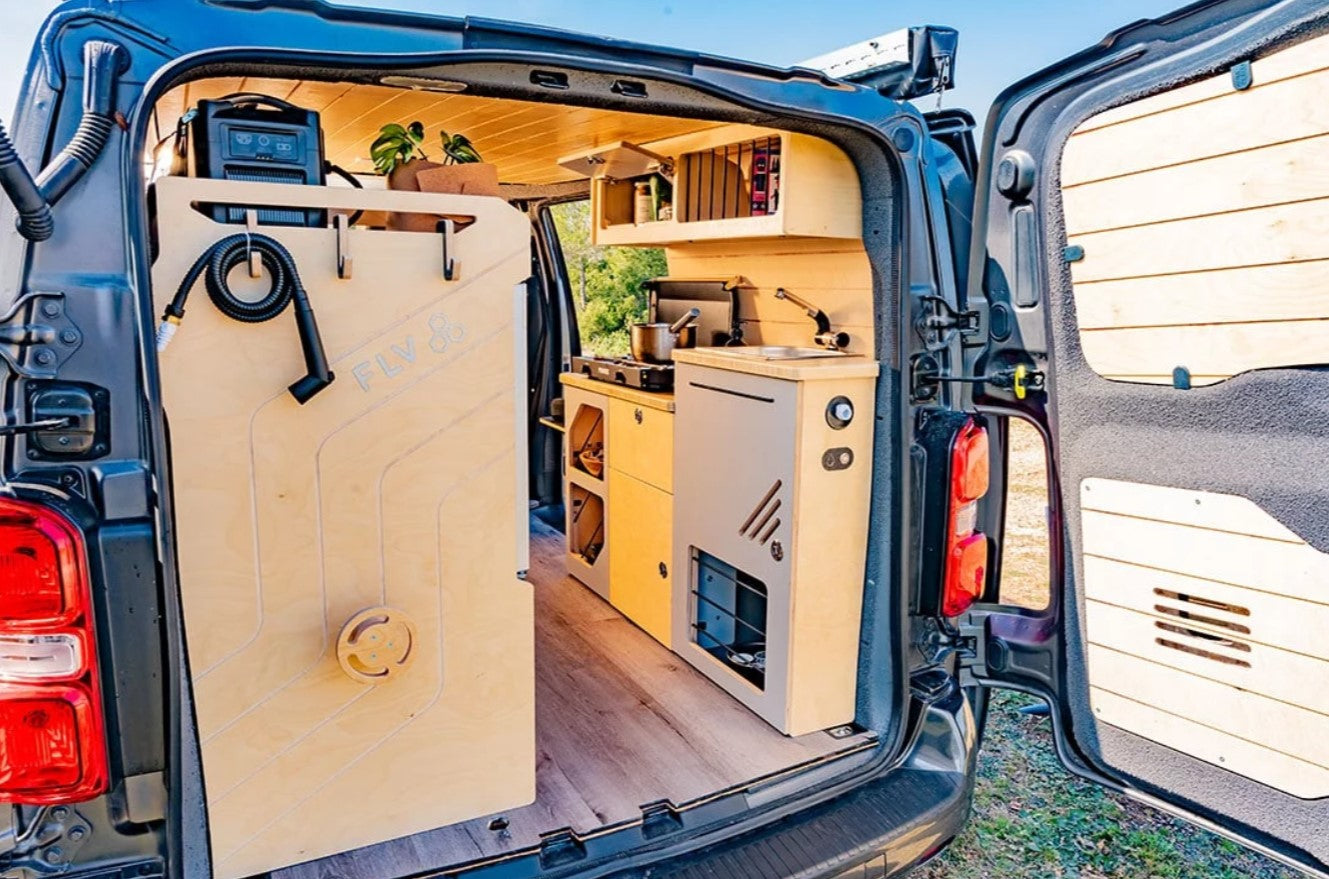 interior de un van equipado con zona de cocina y fregadero