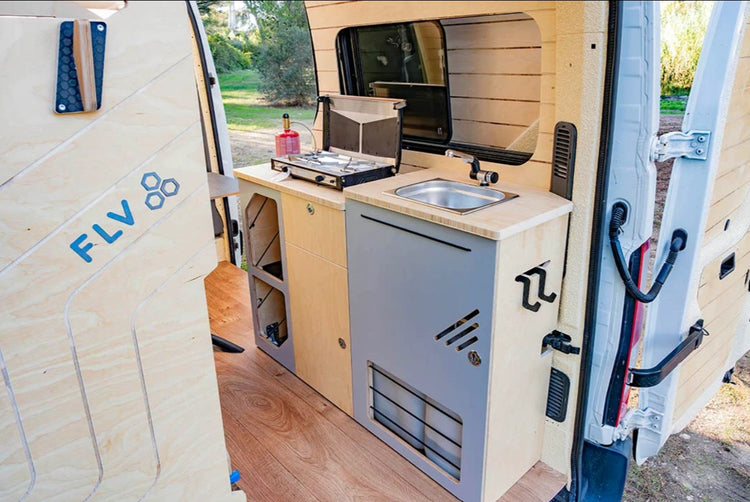 Vista trasera de un van equipado con un módulo de fregadero y cocina en el borde