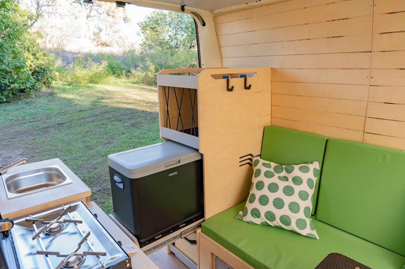 asiento verde en una furgoneta con muebles y nevera