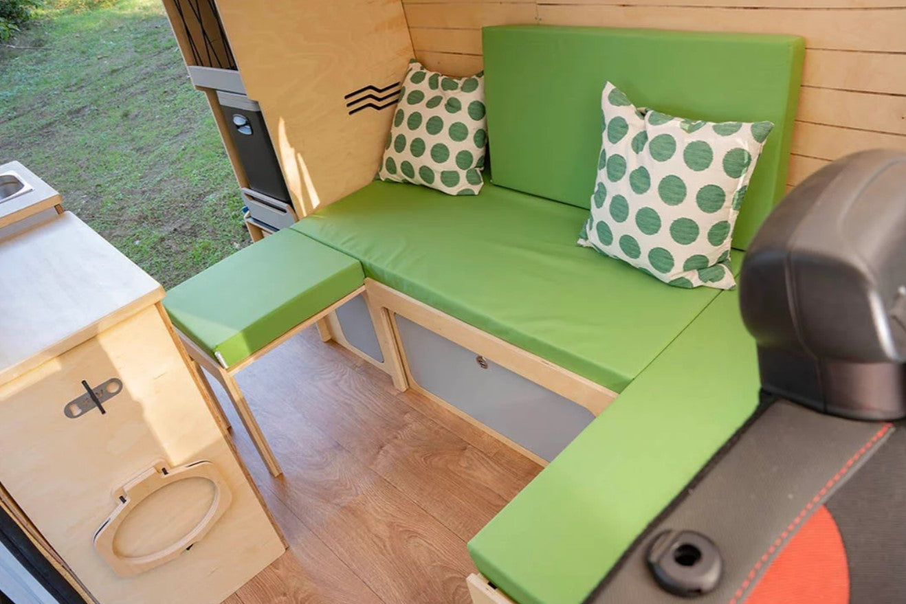 banco-cama verde en forma de U detrás de los asientos