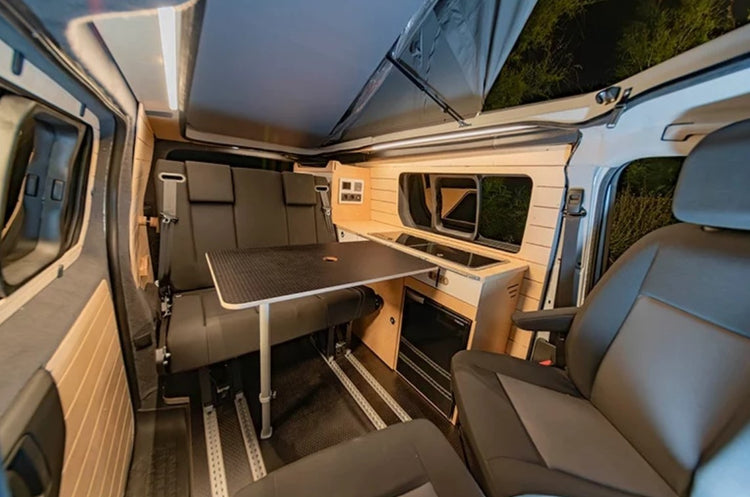 interior de una pequeña furgoneta con asientos giratorios y accesorios de madera