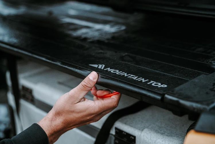 persona empujando con la mano una cubierta de montañaBed Truck