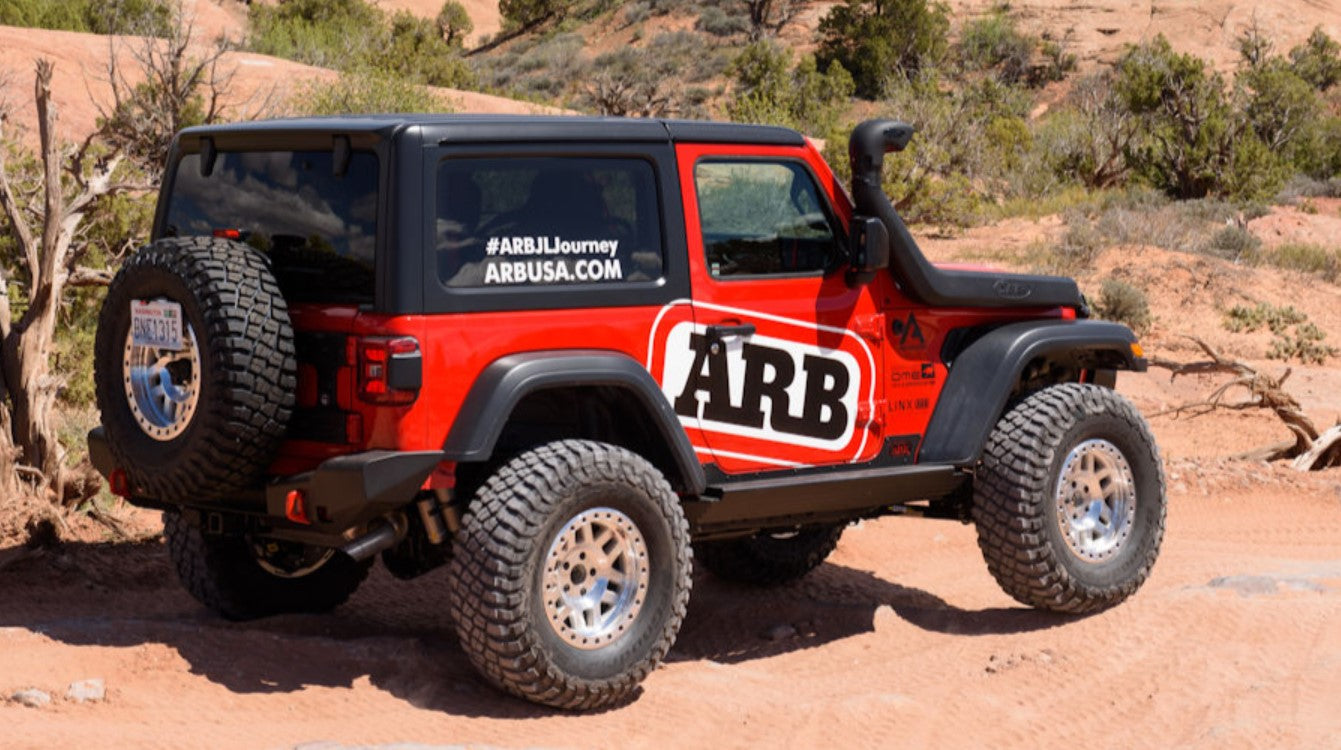 Jeep wrangler JL rojo en el desierto con un gran logo ARB