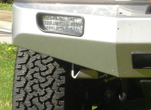 Vista frontal de un vehículo con un neumático y un faro antiniebla