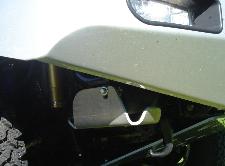 vista lateral de un vehículo en la parte delantera con una pieza metálica bajo el parachoques