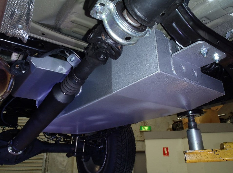 vista desde debajo de un vehículo con un depósito metálico adicional
