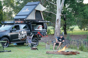 Un hombre disfruta de su espacio de acampada con su 4x4 y una tienda de techo rígida de aluminio Campboss