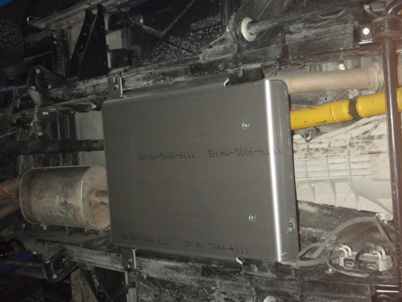 Protección en aluminio fijado bajo un vehículo sucio para la caja de transferencia
