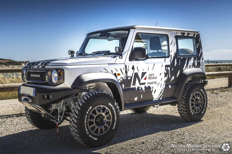 suzuki jimny blanco y negro presentado en una pista