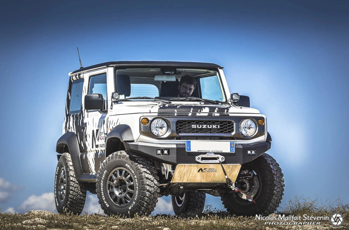 vista frontal de un suzuki jimny con proteccion de aluminio y cielo azul