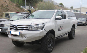 Toyota Hilux blanco aparcado con un snorkel y un PC de acero