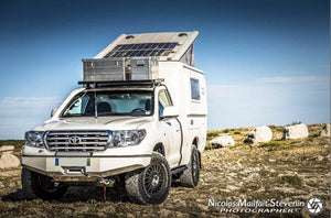 toyota land cruiser blanco aparcado sobre hierba con parachoques reforzado