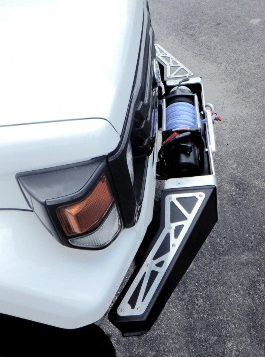 vista lateral de un vehículo con parachoques y estribos de acero negro