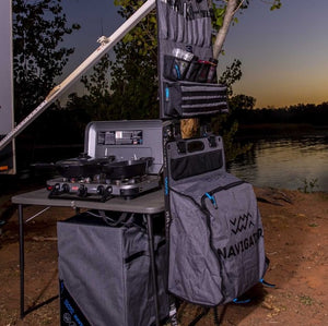 delante de un lago barbacoa y bolsas con utensilios