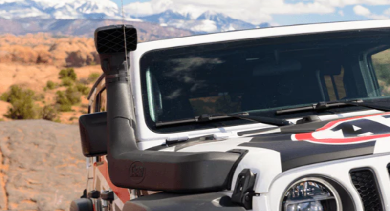vista frontal de un jeep con un snorkel y un paisaje montañoso