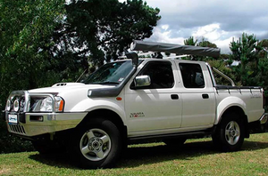 Navara D22 aparcado en la hierba y equipado con un snorkel safari negro