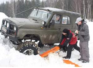 Vehículo en la nieve con manchas de arena